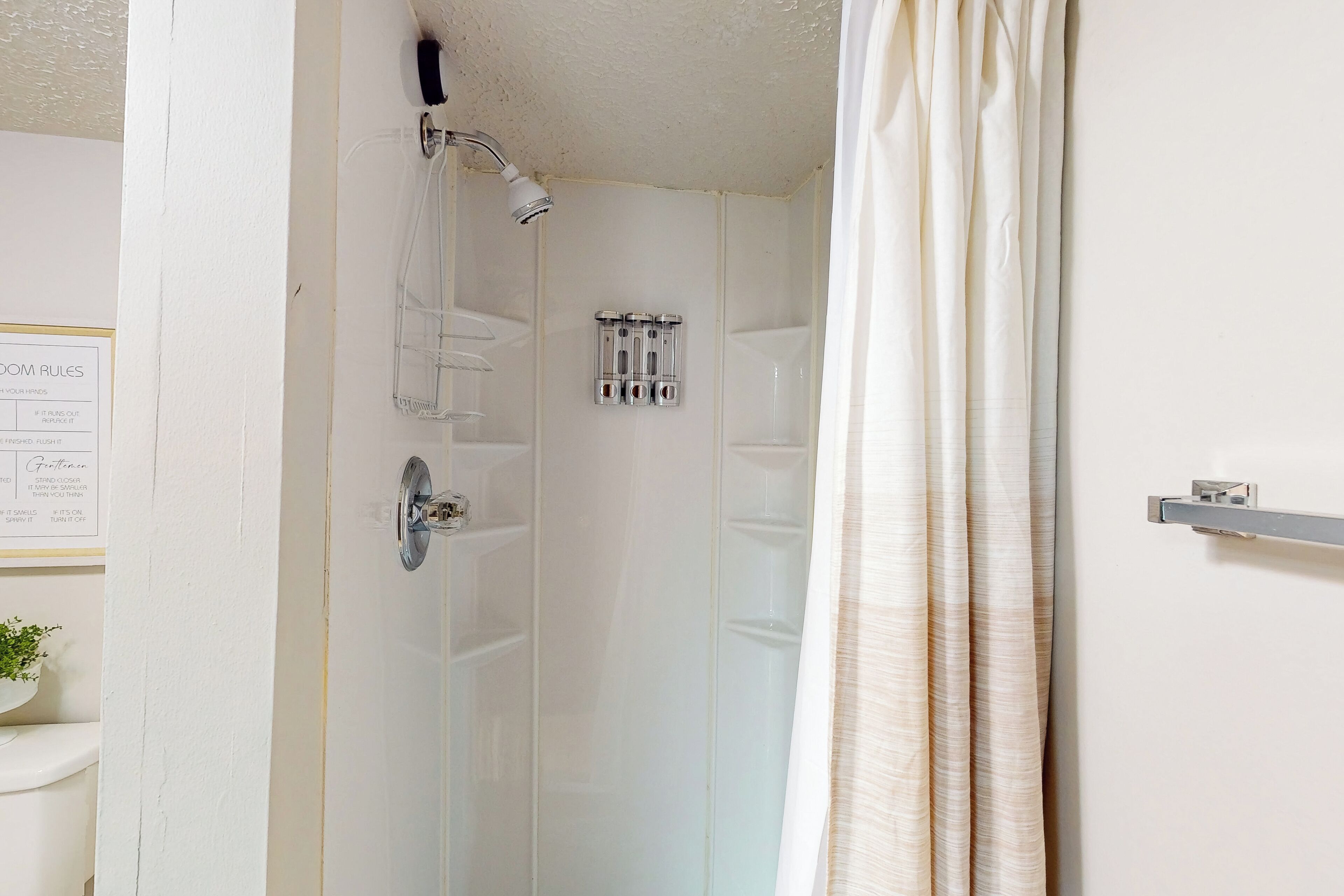 A bathroom with a shower, a toilet, and a sink.