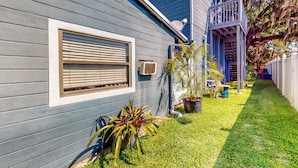 A house with a grey exterior, a window with blinds, a small porch with a railing, and a well-maintained lawn. - Dog-friendly Apt w/ Fenced Yard in Winter Park (Winter Park)