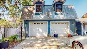 A two-story house with a garage, a driveway, and a parked car. - Dog-friendly Apt w/ Fenced Yard in Winter Park (Winter Park)