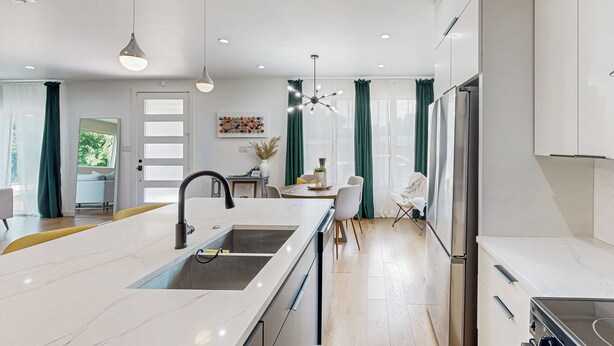 A modern kitchen with a central island, built-in appliances, and a dining area with a view. - Modern Dallas Retreat 5 Mi to Dtwn: Pets Welcome (Dallas)