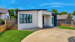 A modern two-story house with a large window, a front porch, and a well-maintained lawn. - Modern Dallas Retreat 5 Mi to Dtwn: Pets Welcome (Dallas)