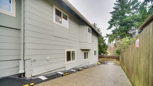 A grey building with a paved driveway and a wooden fence. - Walk to Light Rail: Quiet Judkins Park Home Base! (Seattle)