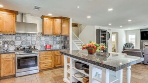 A modern kitchen with wooden cabinets, a granite countertop, and a built-in oven. - 4BR Home w/ Private Pool, Patio & Grill (Glendale)