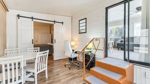 A room with a wooden floor, white furniture, a desk with a lamp, and a staircase with orange steps. - Resort Amenities, 7 Mi to Dtwn: Sarasota Home! (Sarasota)