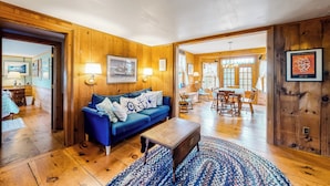 Uma sala de estar aconchegante com um sofá azul, mesa de centro de madeira e um tapete estampado.