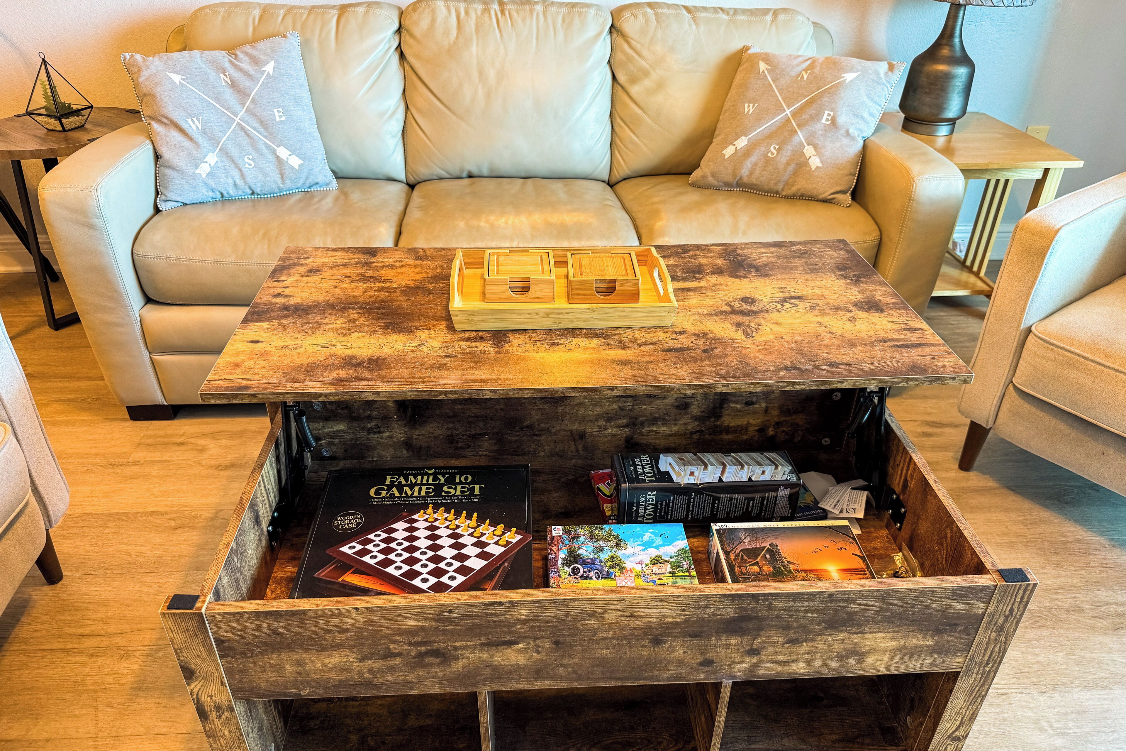 A cozy living room with a wooden coffee table, a sofa, and a drawer unit containing board games and books.