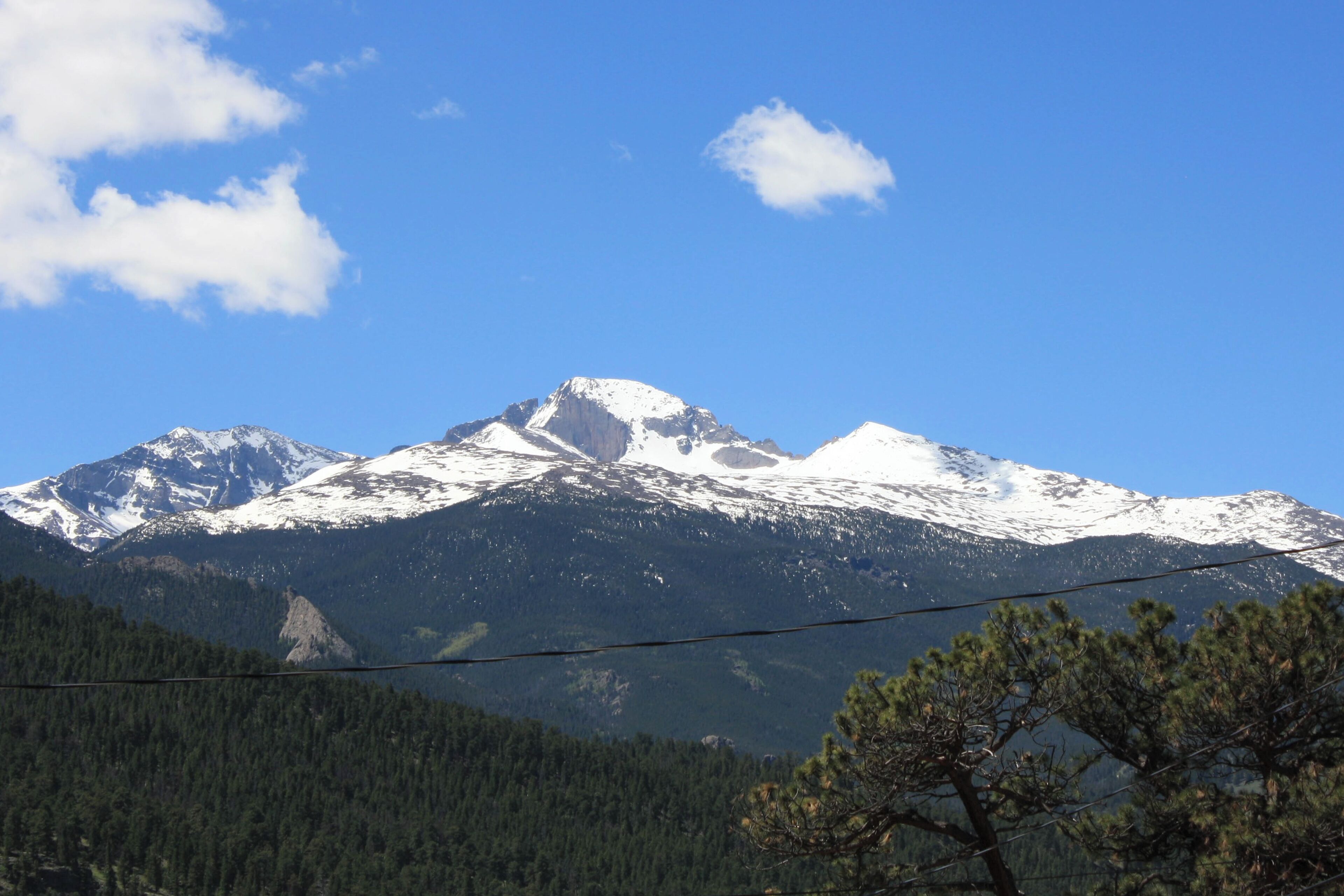 Una montaña con picos nevados y un cielo azul despejado.