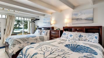 Quarto com duas camas, mesa de cabeceira, cômoda e um quadro na parede.