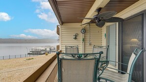 Ein Balkon mit Blick auf einen See, einem Tisch und zwei Stühlen.