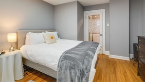 A bedroom with a bed, bedside table, and a dresser. - Easy Metro Access: Wfh-friendly Apt 7 Mi to DC! (Silver Spring)
