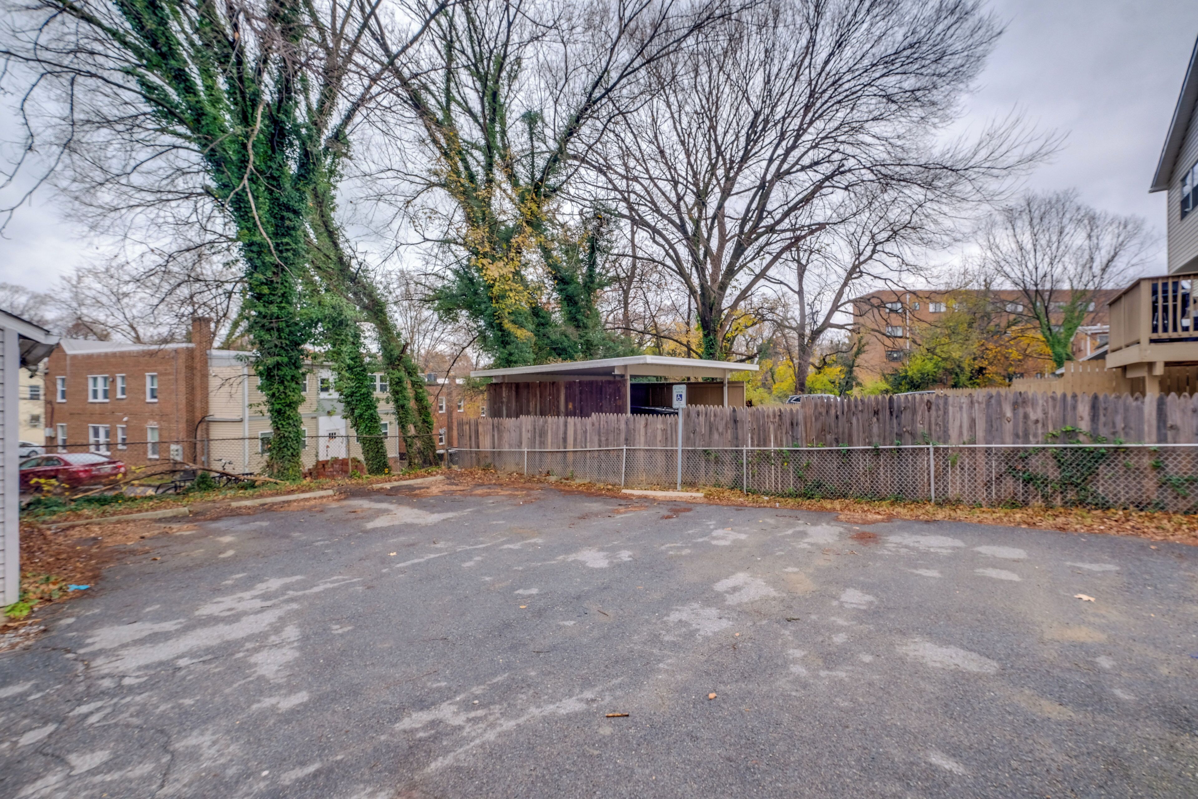 A parking lot with a wooden fence and a small building.