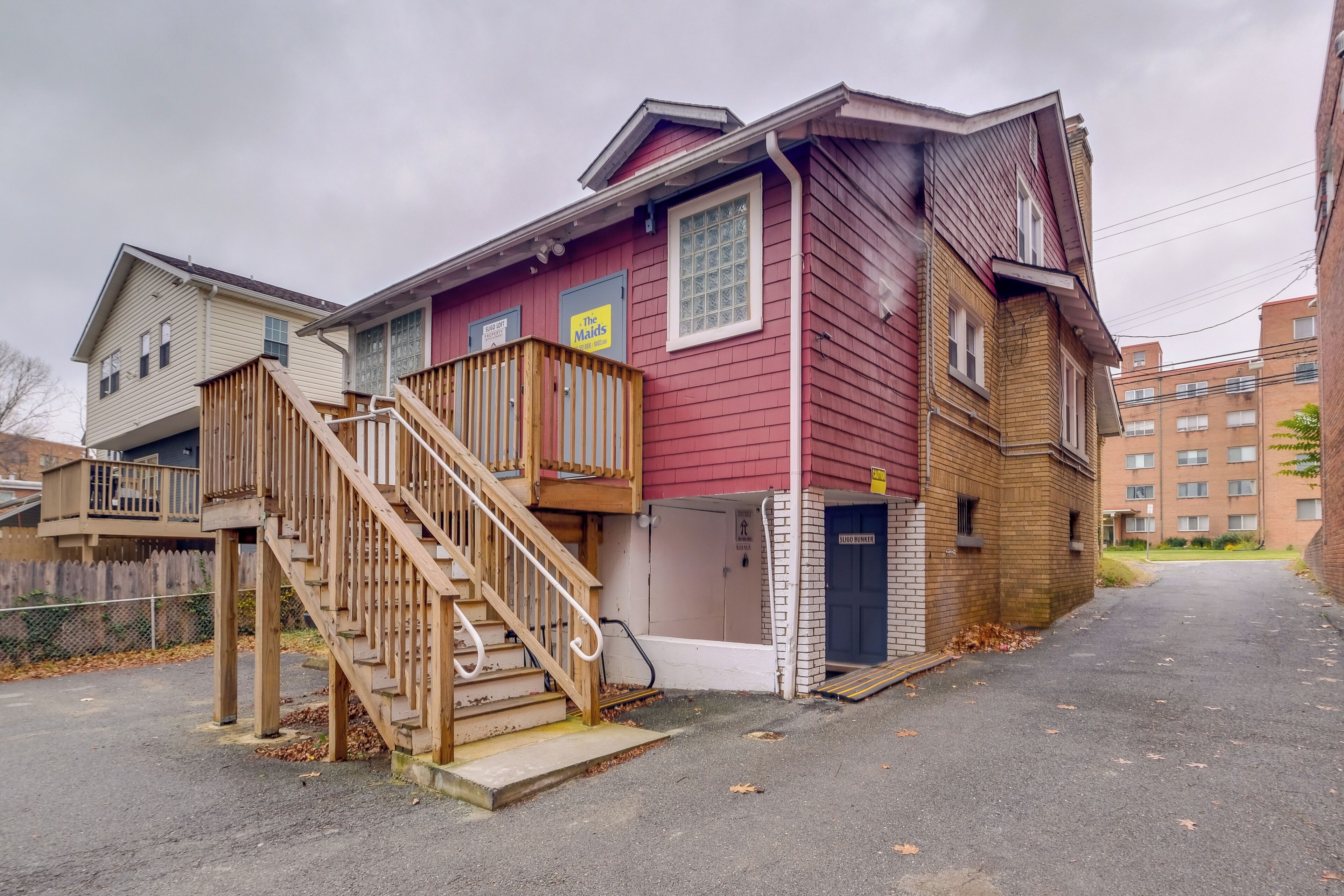 A two-story building with a wooden staircase leading to a balcony.
