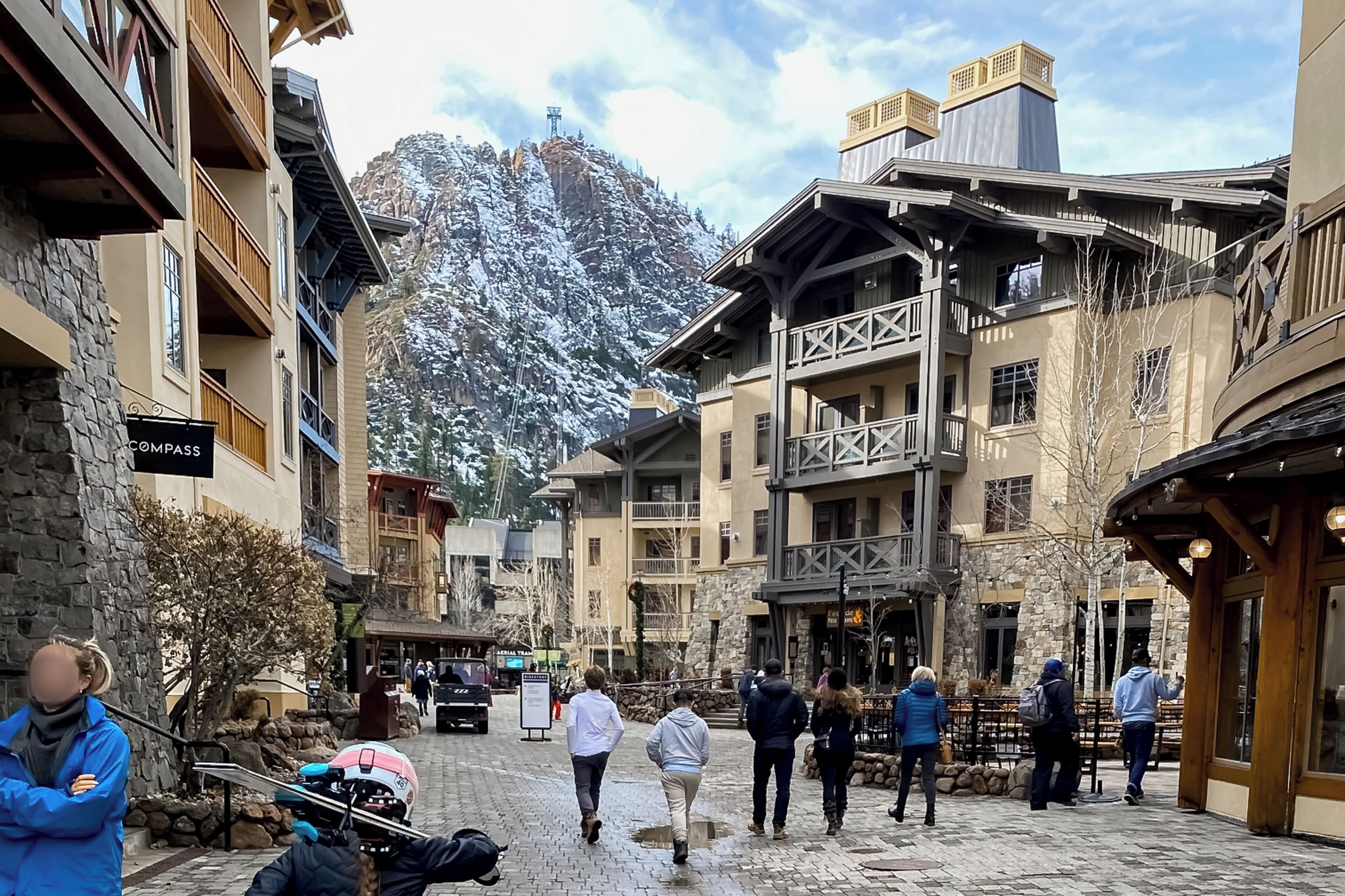 A snow-covered mountain with a ski resort in the background.