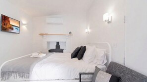 A modern bedroom with a bed, bedside table, and a fireplace. - Nouvelle Studio - Private modern studio near Bendigo CBD (White Hills)