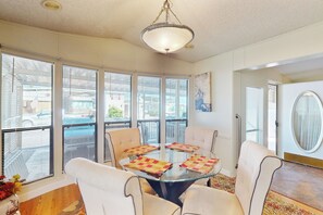 A dining area with a glass table, four chairs, and a chandelier. - Manufactured w/ Pools, Hot Tubs, Pickleball, AC (Surprise)