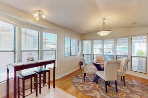 A dining area with a wooden table, four chairs, and a patterned rug. - Manufactured w/ Pools, Hot Tubs, Pickleball, AC (Surprise)