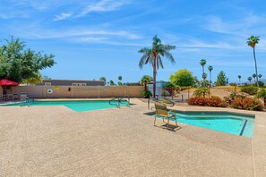 A pool area with two pools, palm trees, and a red umbrella. - Manufactured w/ Pools, Hot Tubs, Pickleball, AC (Surprise)