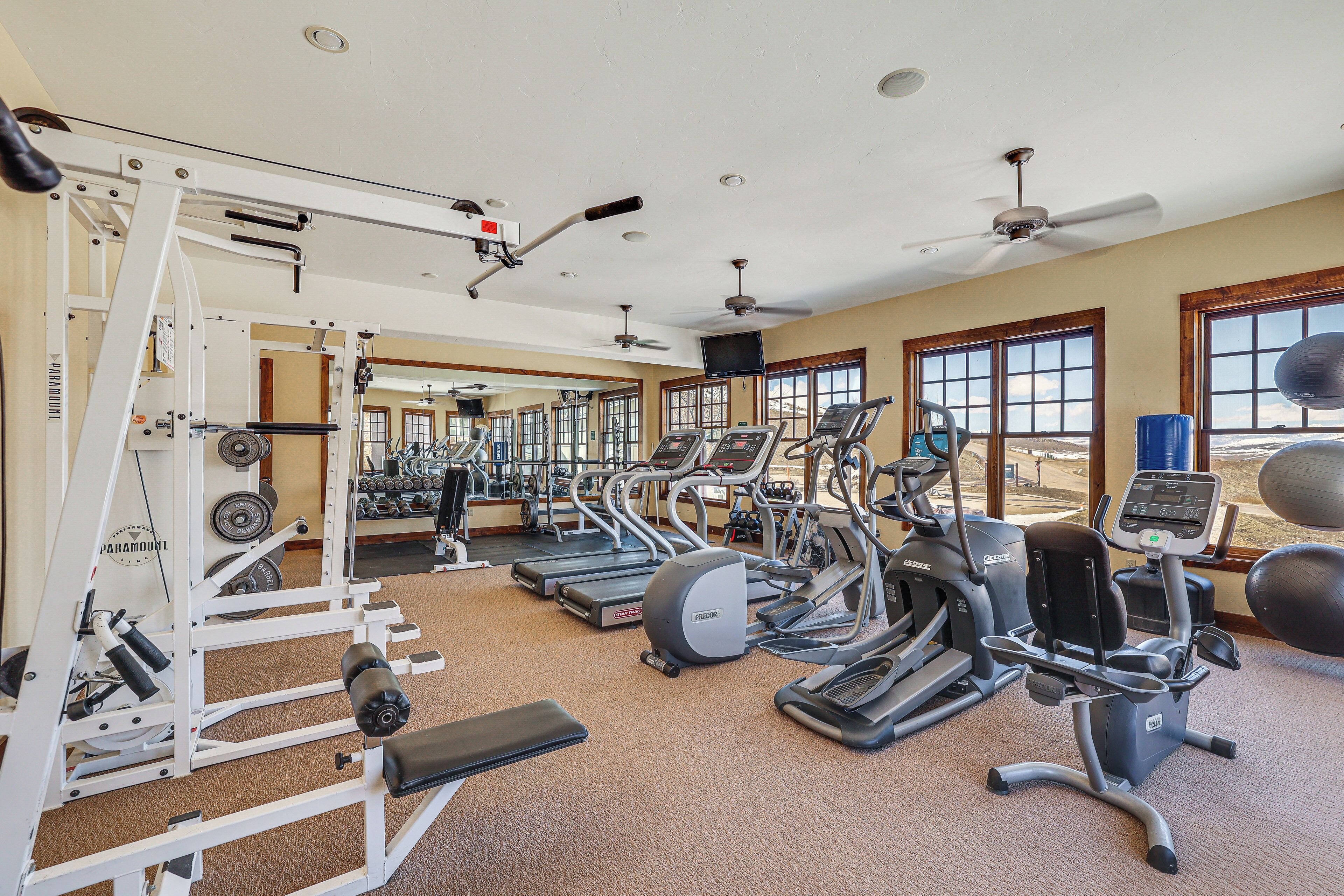 A gym with treadmills, elliptical machines, and weight equipment.