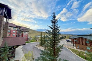 A residential area with a multi-story building, a single-story building, and a prominent evergreen tree. - Granby Ranch Condo w/ Mtn-view: Trails & Hot-tub! (Granby)