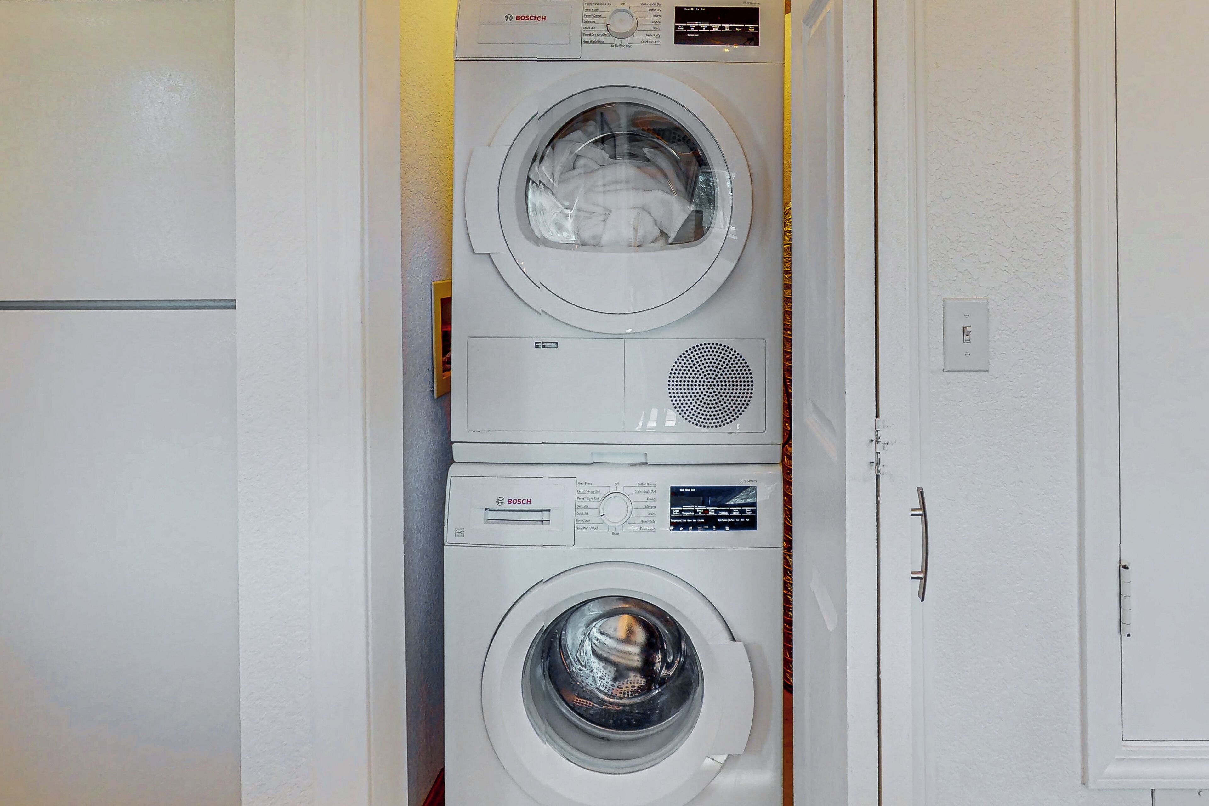 A stacked washer and dryer unit in a laundry room.