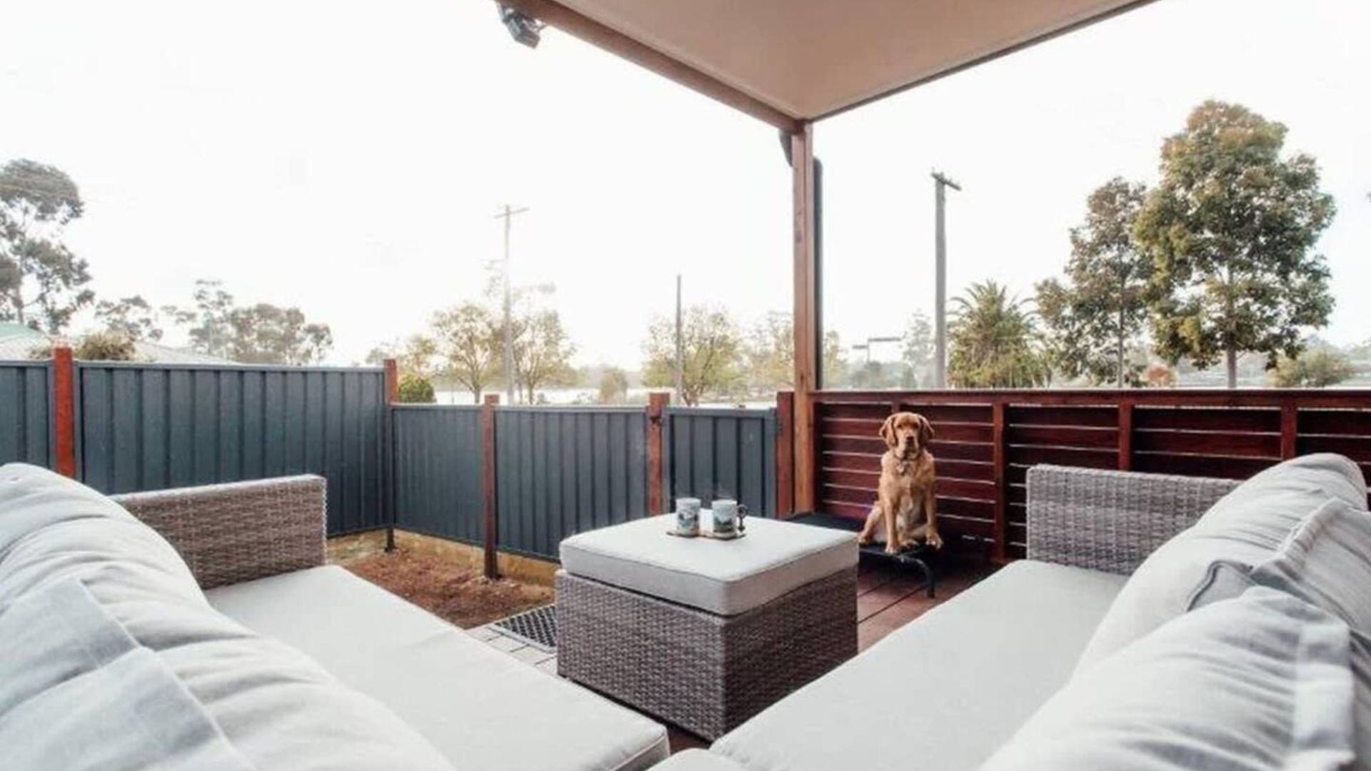 A covered outdoor seating area with wicker furniture and a small table.