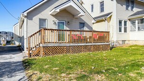 A two-story house with a wooden deck and a small front porch. - Pet-friendly Home 2 Mi to Downtown Des Moines! (Des Moines)