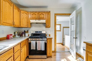 A kitchen with wooden cabinets, a stainless steel stove, and a tiled backsplash.