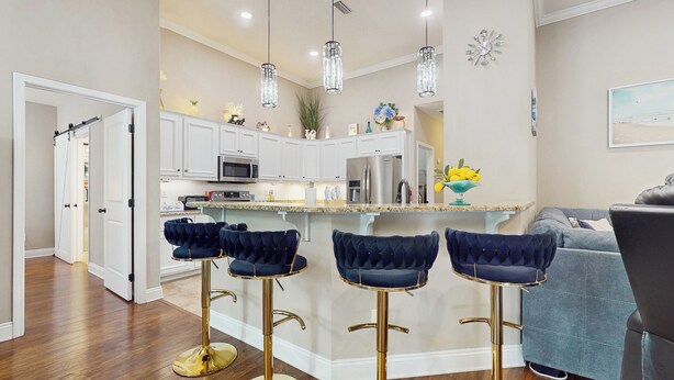 A modern kitchen with white cabinets, stainless steel appliances, and a bar area with velvet barstools. - 2 Mi to Beach! Group-friendly Navarre Getaway (Navarre)