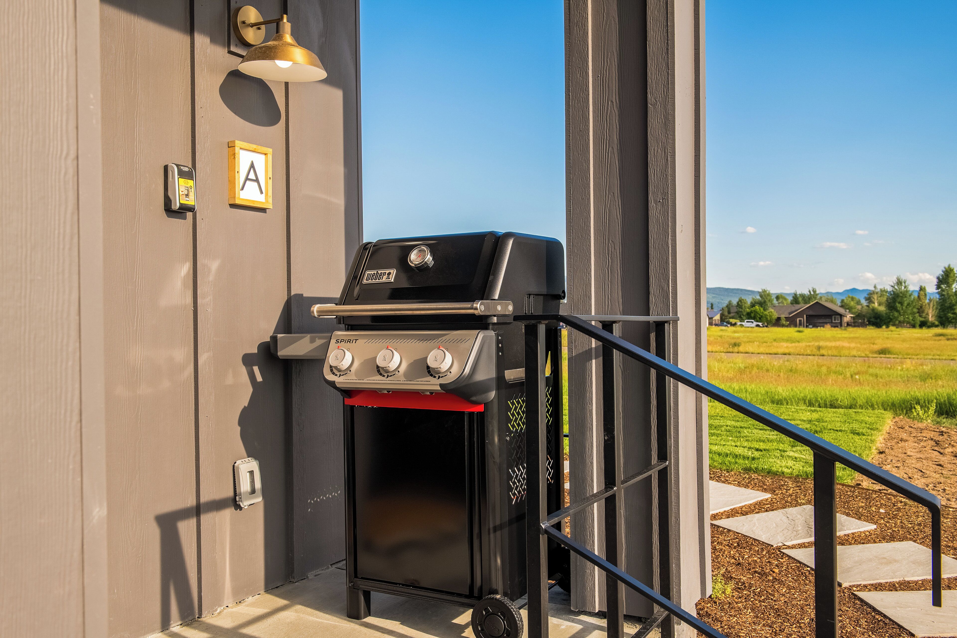 A portable grill with controls, a mailbox, and a door with a 'P' sign.