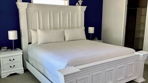 A white bed with a decorative headboard in a room with blue walls.