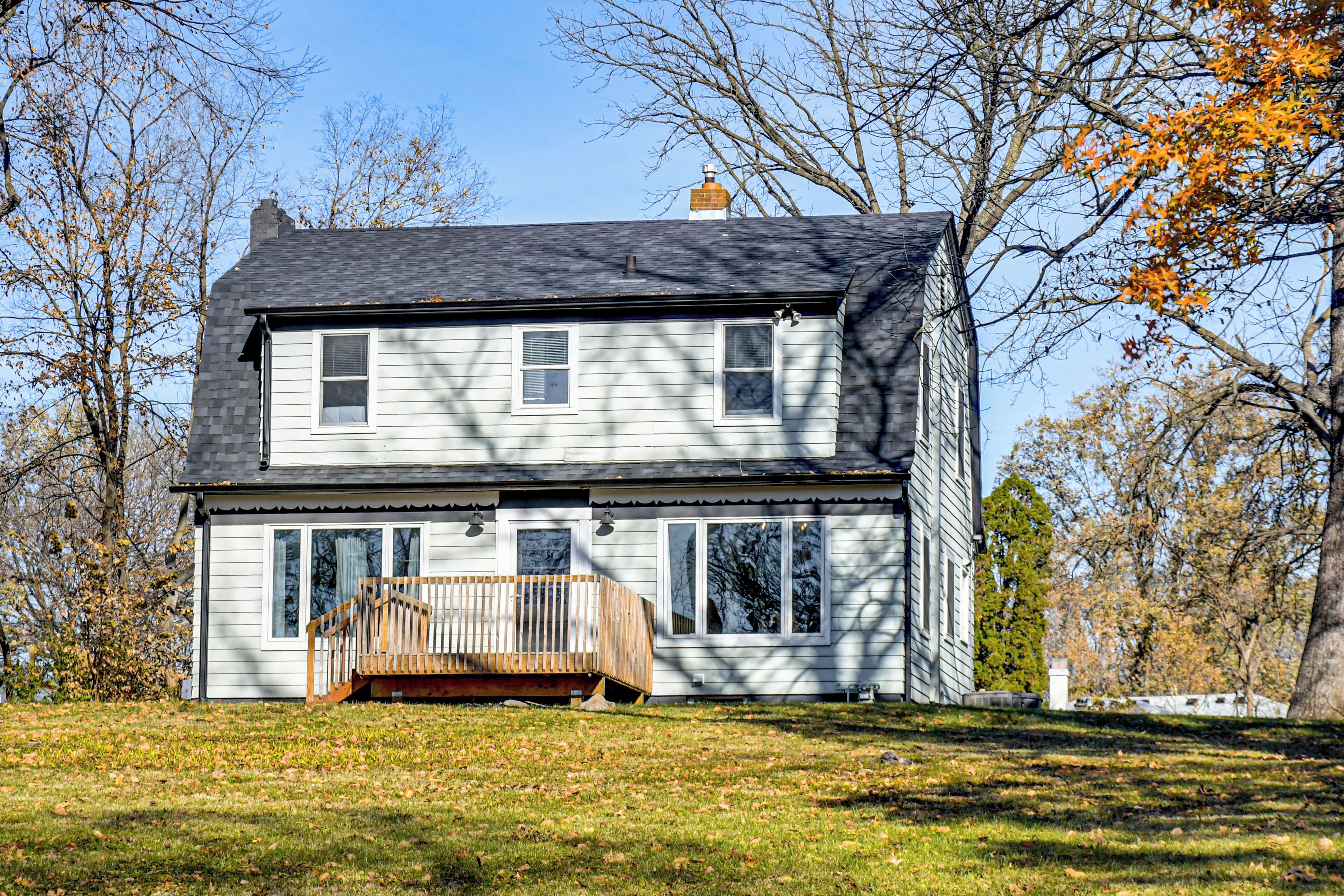 A two-story house with a front porch and a chimney.