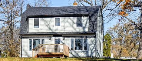 A two-story house with a front porch and a chimney.