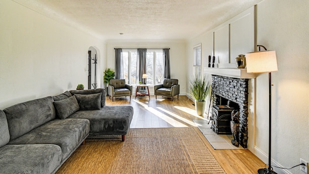 A modern living room with a sectional sofa, a fireplace, and a dining area. - Home w/ Spacious Yard, 3 Mi to Dtwn Des Moines! (Des Moines)