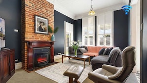 Una sala de estar con chimenea, un sofá, una mesa de centro y un televisor.