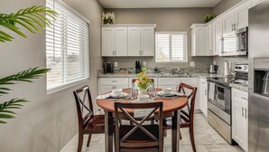 A modern kitchen with white cabinets, a granite countertop, and stainless steel appliances. - Near Casino & Dtwn! Tucson Townhome: Saguaro NP (Tucson)