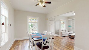 A dining area with a wooden table and chairs, a ceiling fan, and a view through a window. - 2BR Home w/ Mountain View, W & D, Private Yard (Ashton)