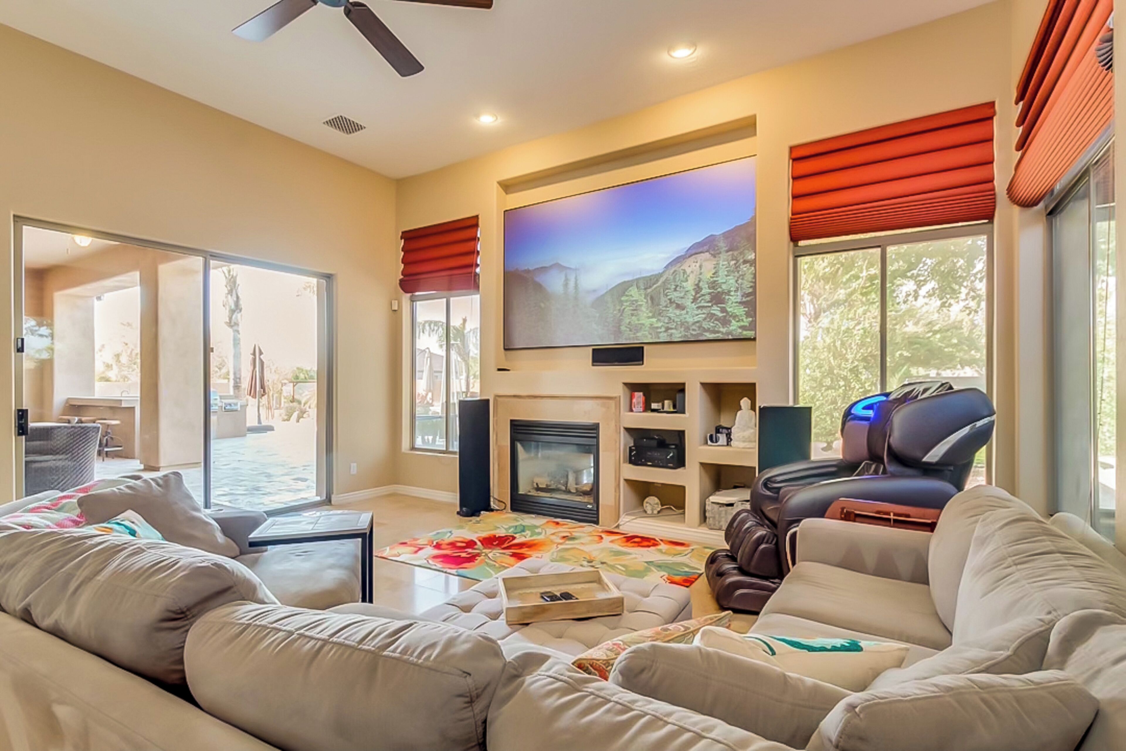 Una sala de estar con chimenea, un televisor de pantalla plana grande y un sillón de cuero reclinable.