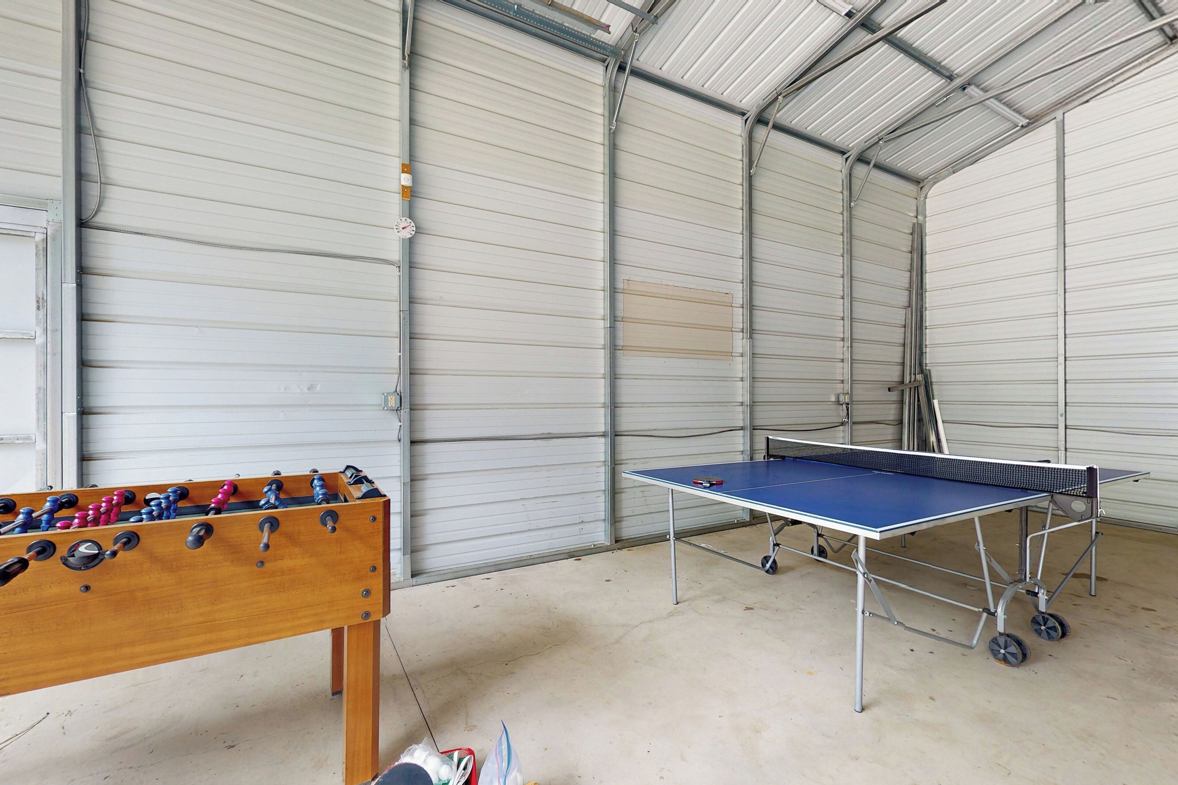 Un grand espace intérieur comprenant une table de baby-foot et une table de ping-pong.