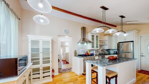 A modern kitchen with white cabinets, a stainless steel refrigerator, and a granite countertop island. - Centrally Located! Dog-friendly San Rafael Home (San Rafael)