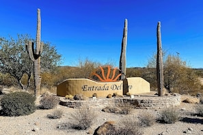 A desert landscape with a sign reading "Entrada Del Oro".