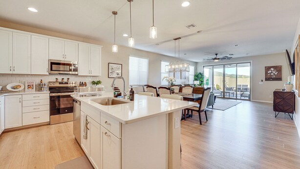 A spacious kitchen with white cabinets, a large island, stainless steel appliances, pendant lighting, and a view to a patio area. - Stargazing Haven in Gold Canyon w/ Mtn Views (Gold Canyon)