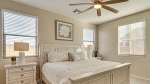A bedroom with a large bed, a nightstand, a ceiling fan, and a window with blinds. - Stargazing Haven in Gold Canyon w/ Mtn Views (Gold Canyon)