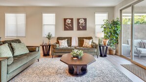 A living room with a sofa, coffee table, and decorative items. - Stargazing Haven in Gold Canyon w/ Mtn Views (Gold Canyon)