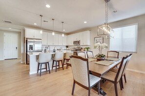 A modern kitchen with white cabinets, stainless steel appliances, and a central island.