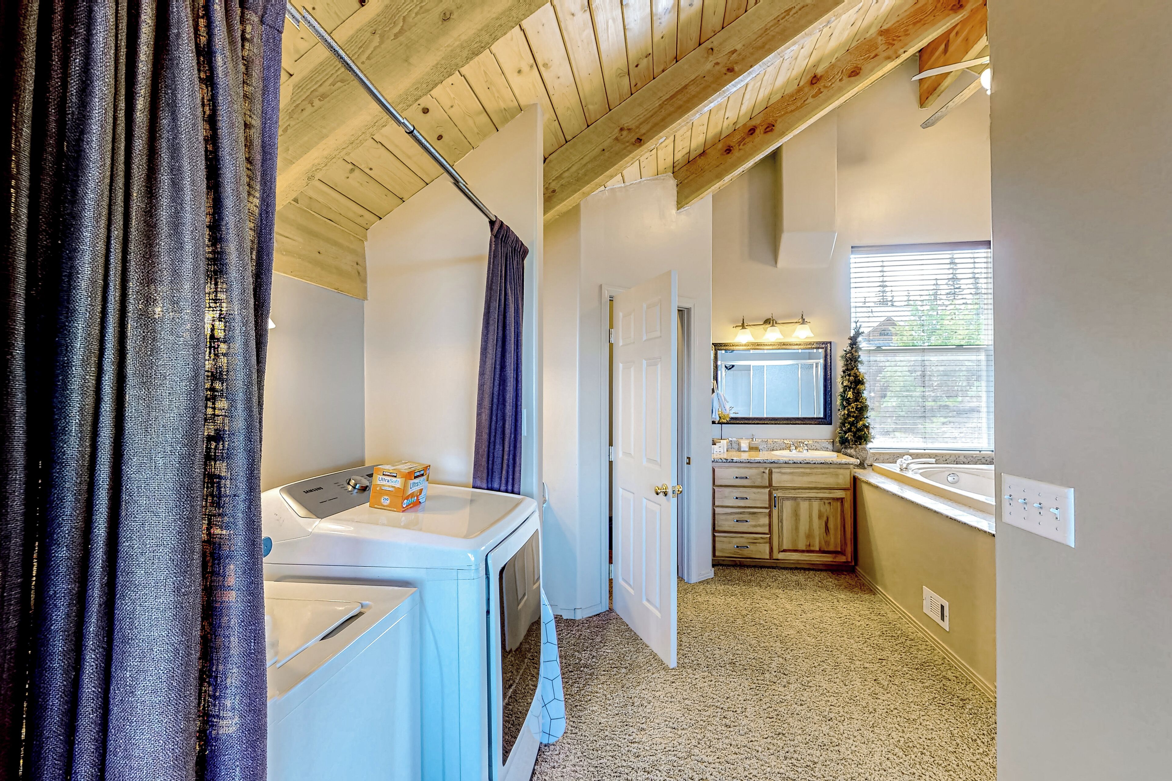A laundry room with a washing machine, a dryer, and a small sink.