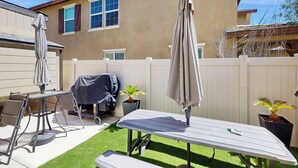 A patio with a table and chairs, a barbecue grill, and a potted plant. - Pool & Hot Tub Access: Cozy Perris Tiny Home (Perris)