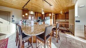 A spacious kitchen with wooden cabinets, a granite countertop, and pendant lighting. - Brian Head 'view-topia' w/ Mtn Views & King Suite (Brian Head)