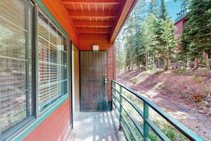 A wooden building with large windows and a balcony overlooking a forested area. - Giant Steps #38 Condo in Brian Head (Brian Head)
