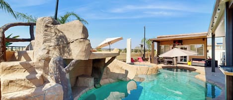 Une piscine entourée d’un paysage rocheux et un bâtiment doté d’un espace extérieur aménagé pour s’asseoir.