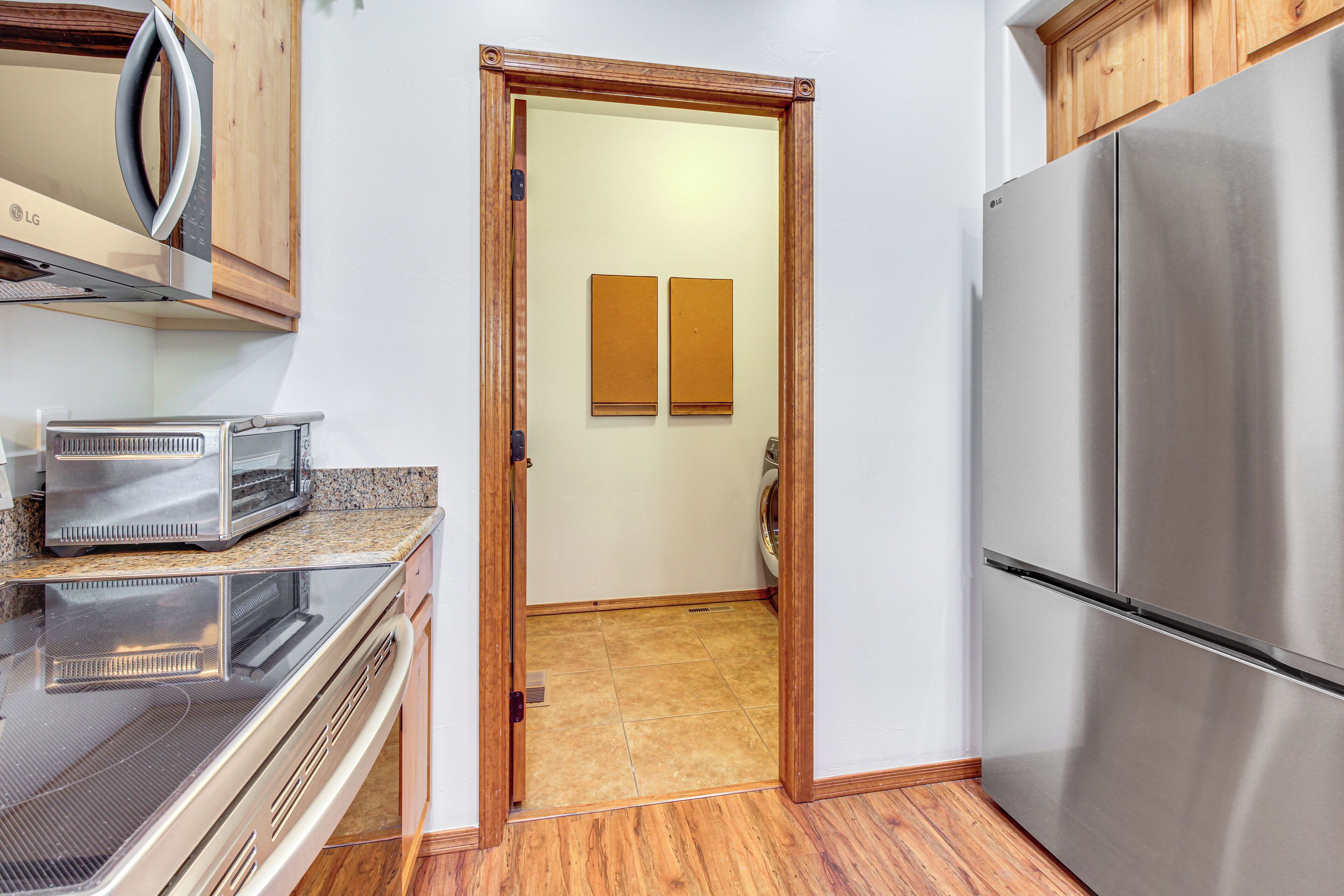 A compact kitchen with a stainless steel refrigerator, a microwave, and a toaster oven.